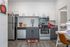 Modern kitchen with stainless steel appliances, sleek cabinetry, and chic backsplash design, accompanied by a stylish workspace and elegant flooring.