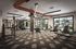 Modern fitness center with cutting-edge exercise equipment, large windows, and stylish industrial design.