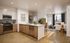 Elegant open-plan kitchen and living area with modern appliances, sleek wooden floors, and natural light streaming through large windows.