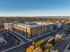 Modern apartment complex surrounded by vibrant autumn foliage with breathtaking mountain views in the distance.