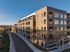 Modern apartment building featuring large windows and private balconies, set in an accessible urban location with scenic views.