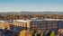 Modern apartment complex surrounded by vibrant autumn trees and scenic mountain views, offering a blend of urban living and natural beauty.