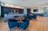 Modern communal lounge with stylish seating, elegant lighting, and large wall-mounted TVs, ideal for luxurious relaxation and entertainment.