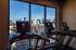 Modern apartment gym featuring treadmills with a stunning cityscape view through large windows.