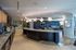 Contemporary lounge area with sleek bar counter, modern lighting, and stylish seating, perfect for social gatherings.