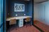 Modern home office with sleek desk, two chairs, stylish wall art, and ambient lighting, perfect for productivity and creativity.
