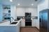 Modern kitchen with sleek white cabinetry, stainless steel appliances, and elegant tile backsplash, perfect for stylish living.