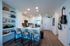 Modern open kitchen with sleek countertops and bar seating, complemented by stylish shelving and artistic accents.