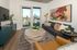 Modern living room with floor-to-ceiling windows, city views, chic artwork, and stylish furniture.