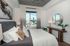 Luxurious bedroom with modern decor, featuring a stunning city view, cozy bed, elegant artwork, and stylish furnishings.