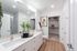 Modern bathroom with sleek double sinks, chic decor, and spacious walk-in closet.