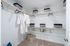Spacious walk-in closet with elegant shelving and ample storage space featuring baskets and hangers.
