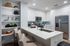 Modern kitchen with sleek white cabinetry, stainless steel appliances, and a stylish breakfast bar with elegant seating.