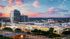 Breathtaking cityscape view at sunset, highlighting a modern high-rise building with vibrant sky and urban skyline.