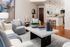 Chic living space featuring modern decor, cozy seating, and a stylish open kitchen with elegant lighting.