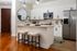 Modern kitchen with sleek white cabinets, stainless steel appliances, and stylish island seating, perfect for entertaining.