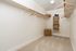 Spacious walk-in closet with elegant shelving, built-in storage baskets, and ample hanging space, perfect for organized living.