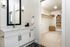Luxurious bathroom with sleek white cabinetry and spacious walk-in closet with organized shelving.
