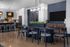 Modern open-plan kitchen and dining area featuring elegant pendant lighting, sleek bar seating, and contemporary furniture with beautiful plant accents.