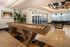 Luxurious recreational area featuring a sleek shuffleboard table, modern pool table, stylish decor, and abundant natural light.