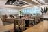 Elegant lounge space with modern furniture, artistic ceiling design, and floor-to-ceiling windows offering a scenic view.
