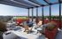 Luxurious rooftop terrace with modern seating, vibrant planters, and panoramic city views, perfect for relaxation and entertainment.