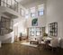 Modern loft living room with high ceilings, elegant spiral staircase, stylish decor, and abundant natural light.
