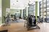Spacious, modern fitness center with state-of-the-art equipment, surrounded by floor-to-ceiling windows offering panoramic views.