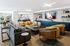 Contemporary open-plan living room with cozy seating, modern decor, and warm lighting, leading into a chic kitchen area.