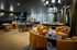 Elegant and modern lounge area featuring vibrant orange chairs, stylish decor elements, and a chic seating arrangement perfect for social gatherings.