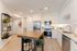 Modern kitchen with sleek stainless steel appliances, bright cabinetry, and a stylish wooden island, creating a warm and inviting space.
