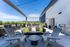 Sleek rooftop terrace featuring modern seating, lush greenery, and stunning views under a clear blue sky.