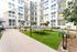 Vibrant apartment courtyard featuring a modern ping pong table, stylish seating areas, lush greenery, and string lights creating a welcoming community space.