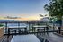 Chic rooftop terrace with modern furniture offering stunning sunset views over the cityscape.
