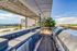 Luxurious rooftop terrace with stainless steel grills, sleek countertop, and panoramic city views under a stylish pergola.