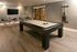 Elegant game room with a sleek pool table, inviting bar stools, and stylish decor, perfect for entertaining guests.