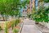 Charming urban courtyard with lush greenery and modern stone planters, offering a peaceful retreat in a sophisticated apartment complex.