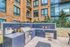 Modern apartment building exterior featuring an elegant outdoor grilling station with sleek stainless steel appliances and lush landscaping.