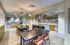 Modern kitchen and dining area with sleek wooden cabinetry, stylish lighting, and an open-concept design perfect for hosting.