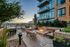 Chic urban apartment balcony with cozy fire pits, modern seating, and a stunning cityscape view at sunset.