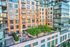 Modern apartment building exterior with spacious balconies and lush green rooftop terrace, offering an urban oasis.