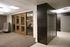 Elegant office space featuring sleek wooden doors, modern seating area, and polished finishes.