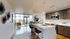Modern open-concept apartment featuring a sleek kitchen, stylish living area, and panoramic city views.