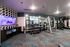 Modern fitness center with state-of-the-art gym equipment, stylish geometric wall design, and vibrant carpet flooring.