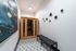 Chic apartment hallway with stylish art, modern lighting, and an elegant wooden sauna.