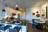 Modern kitchen with sleek countertops, stylish pendant lighting, and a cozy dining nook with contemporary art decor.
