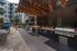 Chic outdoor courtyard with modern grilling station, elegant string lights, and inviting seating area, perfect for entertaining.
