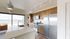 Modern kitchen with sleek stainless steel appliances, stylish cabinetry, and panoramic city view.