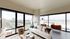 Bright and modern living room in a chic apartment with floor-to-ceiling windows offering stunning cityscape views.