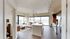 Bright and modern open-concept apartment featuring a sleek kitchen, spacious living area with panoramic windows, and stylish decor.